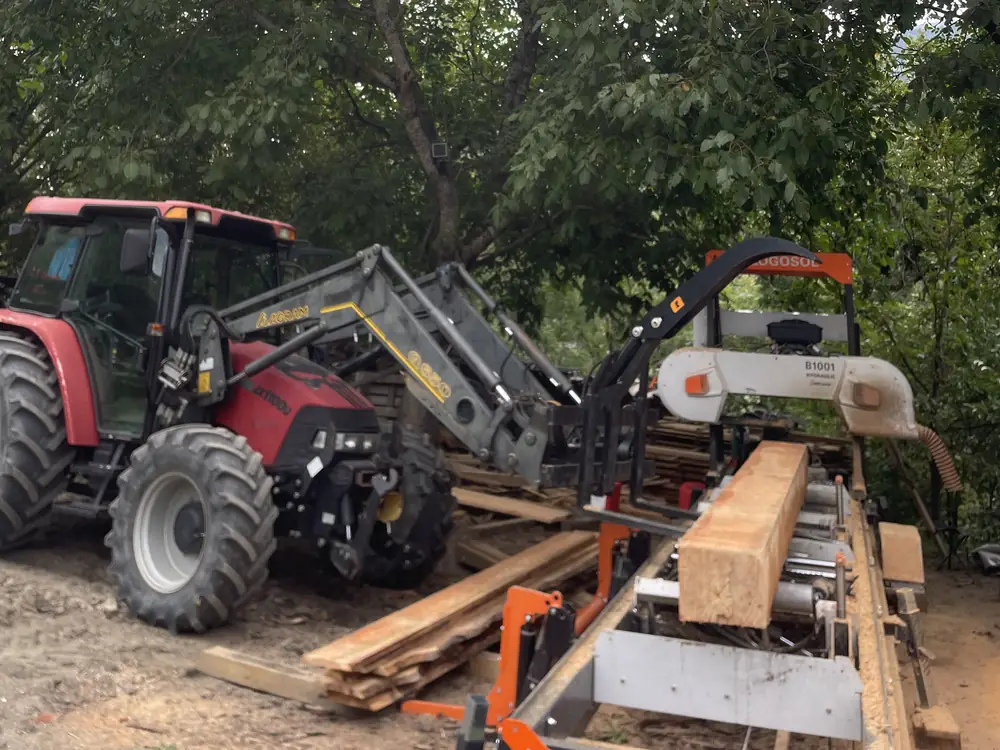 Tracteur et scierie à ruban débitant une poutre
